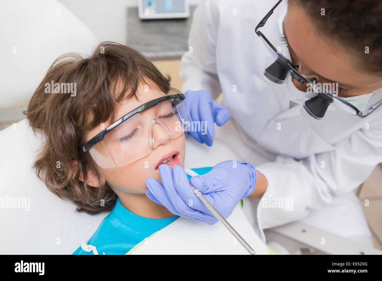 Pédodontiste examinant un peu de garçons dans les dents dentistes président Banque D'Images