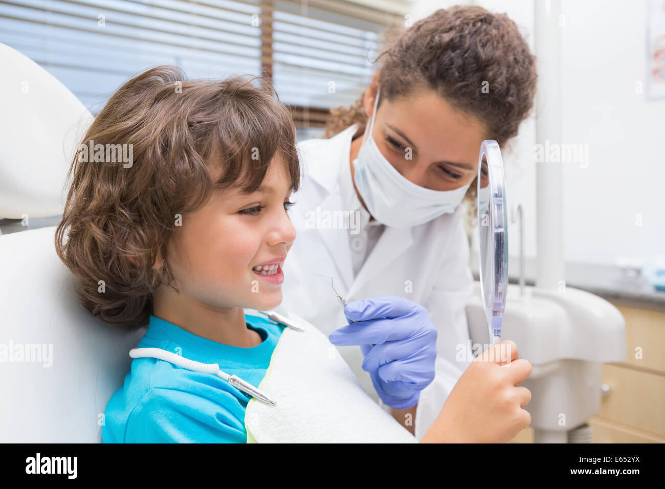 Dentiste pédiatrique petit garçon montrant ses dents dans le miroir Banque D'Images