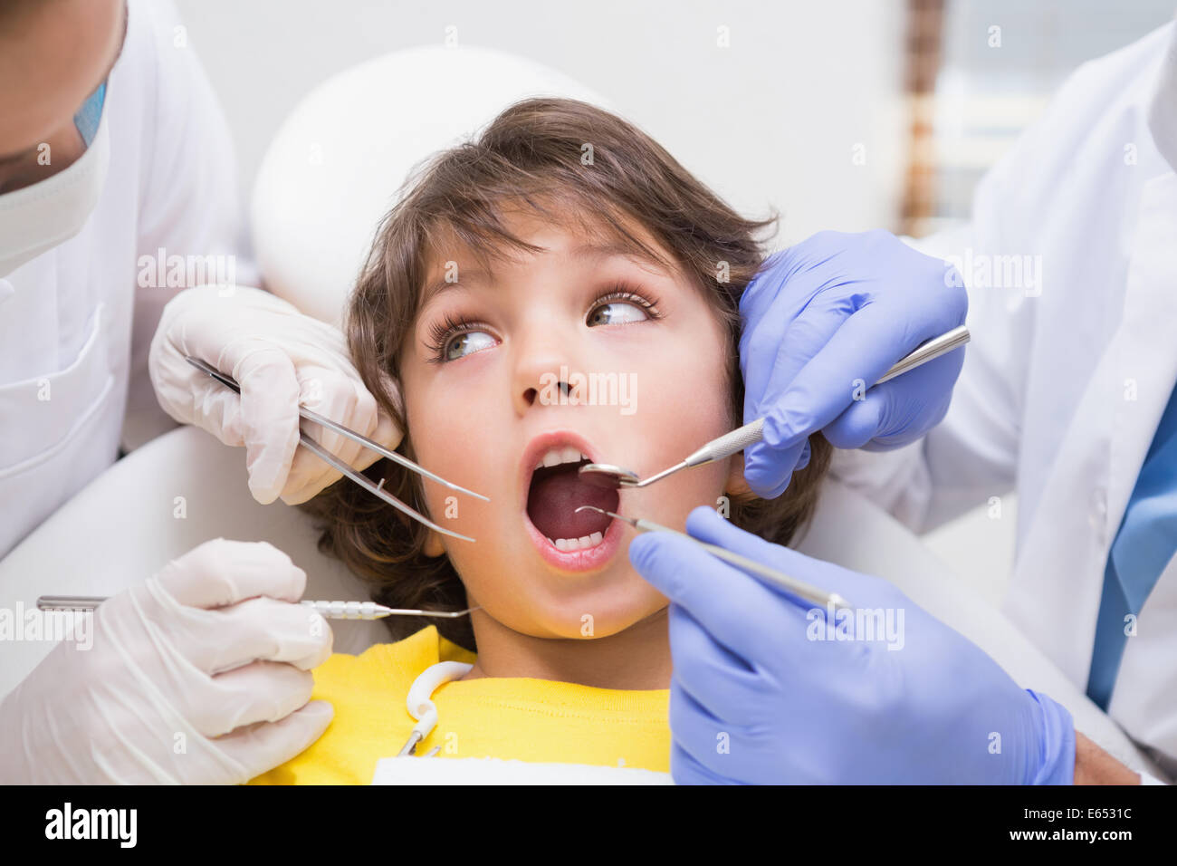 L'examen d'un dentiste pédiatrique petits garçons dents avec son assistant Banque D'Images