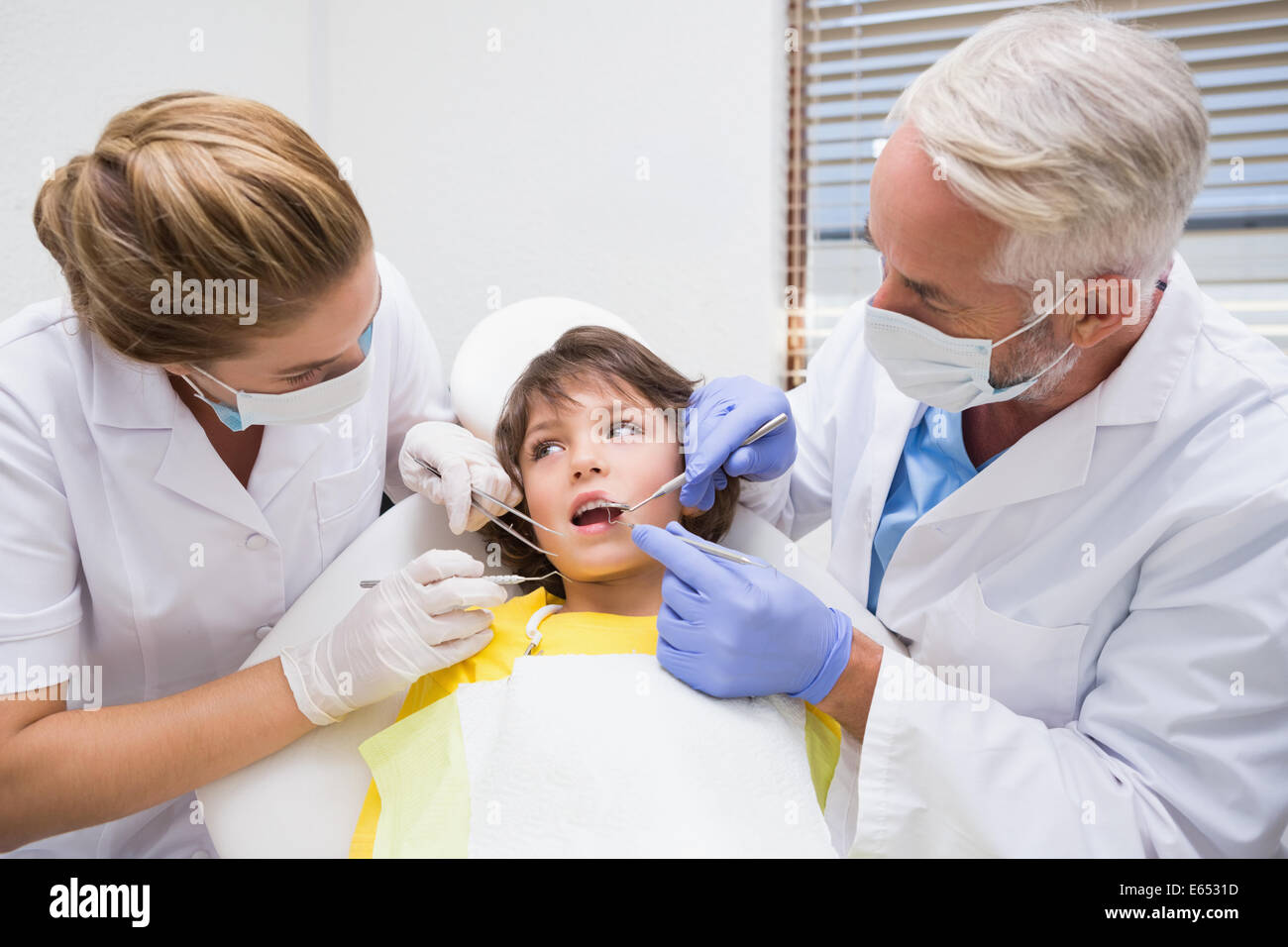 L'examen d'un dentiste pédiatrique petits garçons dents avec son assistant Banque D'Images