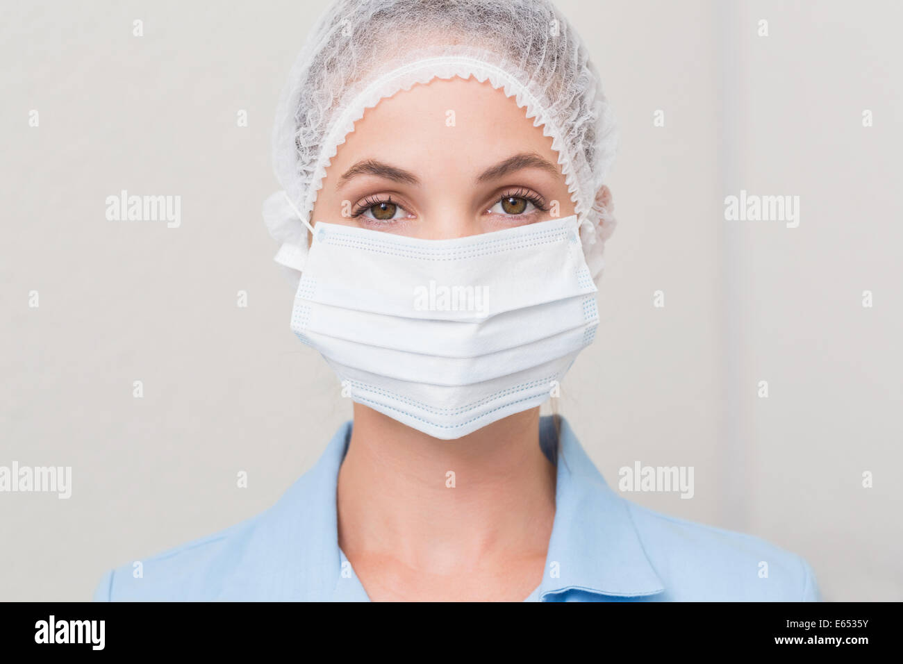 Dentiste en masque chirurgical et cap looking at camera Banque D'Images