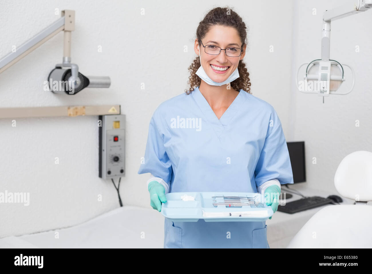 Dentiste en bleu frotte holding tray of tools Banque D'Images