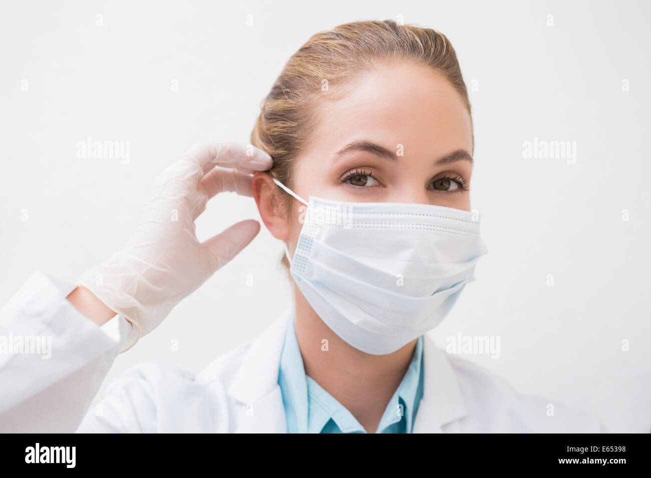 Dentiste de mettre son masque chirurgical Banque D'Images