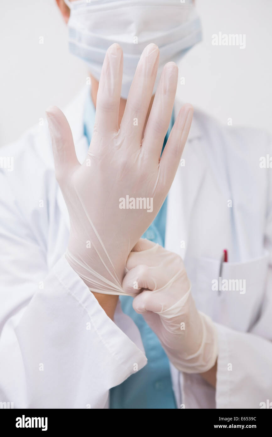 Dentiste tirant sur des gants chirurgicaux Banque D'Images