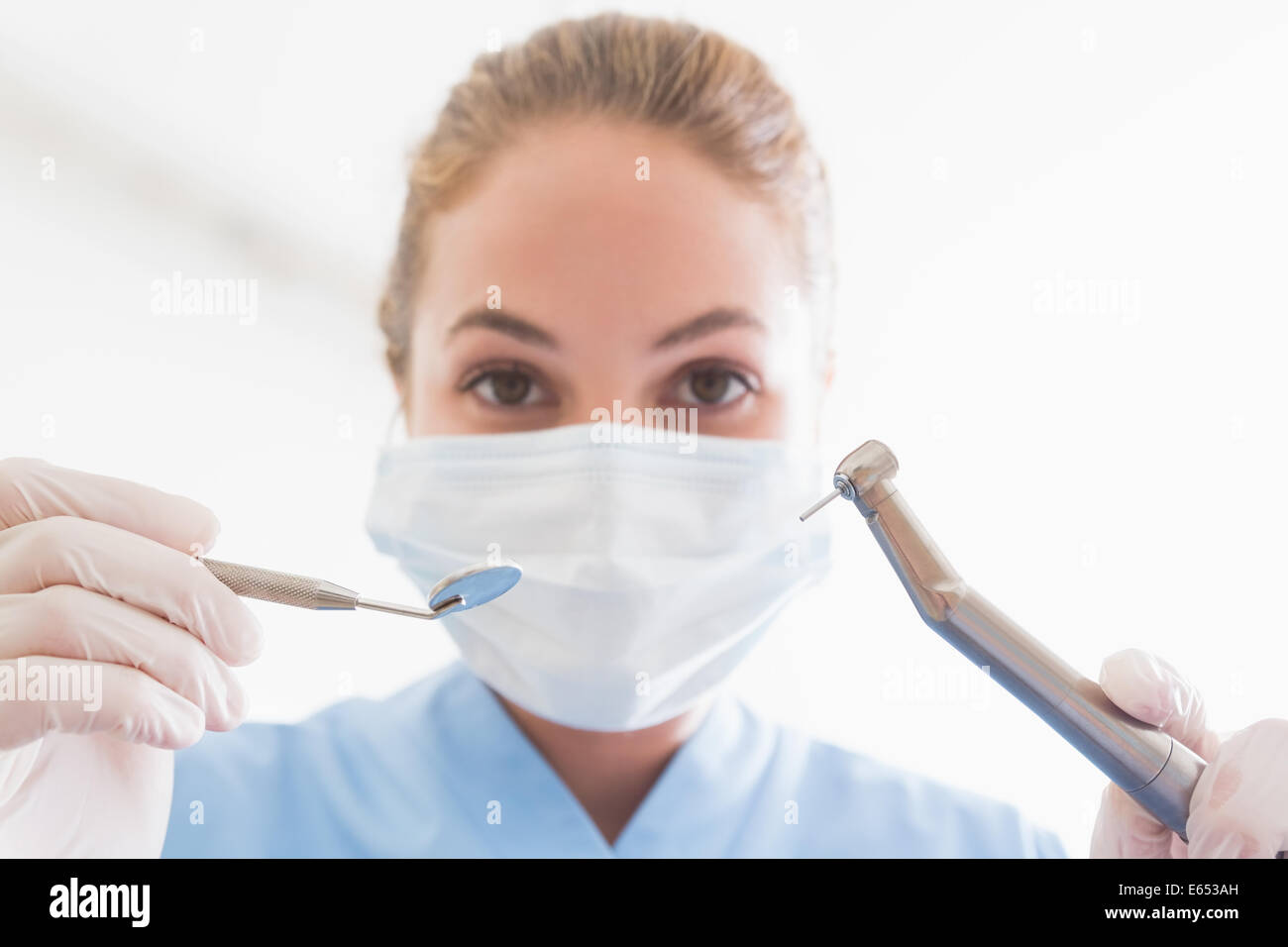 Dentiste en masque chirurgical sur les outils de maintien patient Banque D'Images