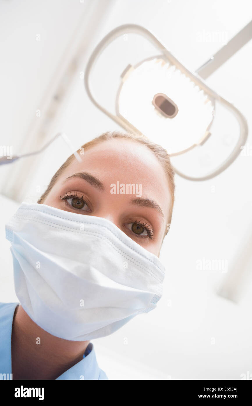 Dentiste en masque chirurgical holding dental explorer plus de patient Banque D'Images
