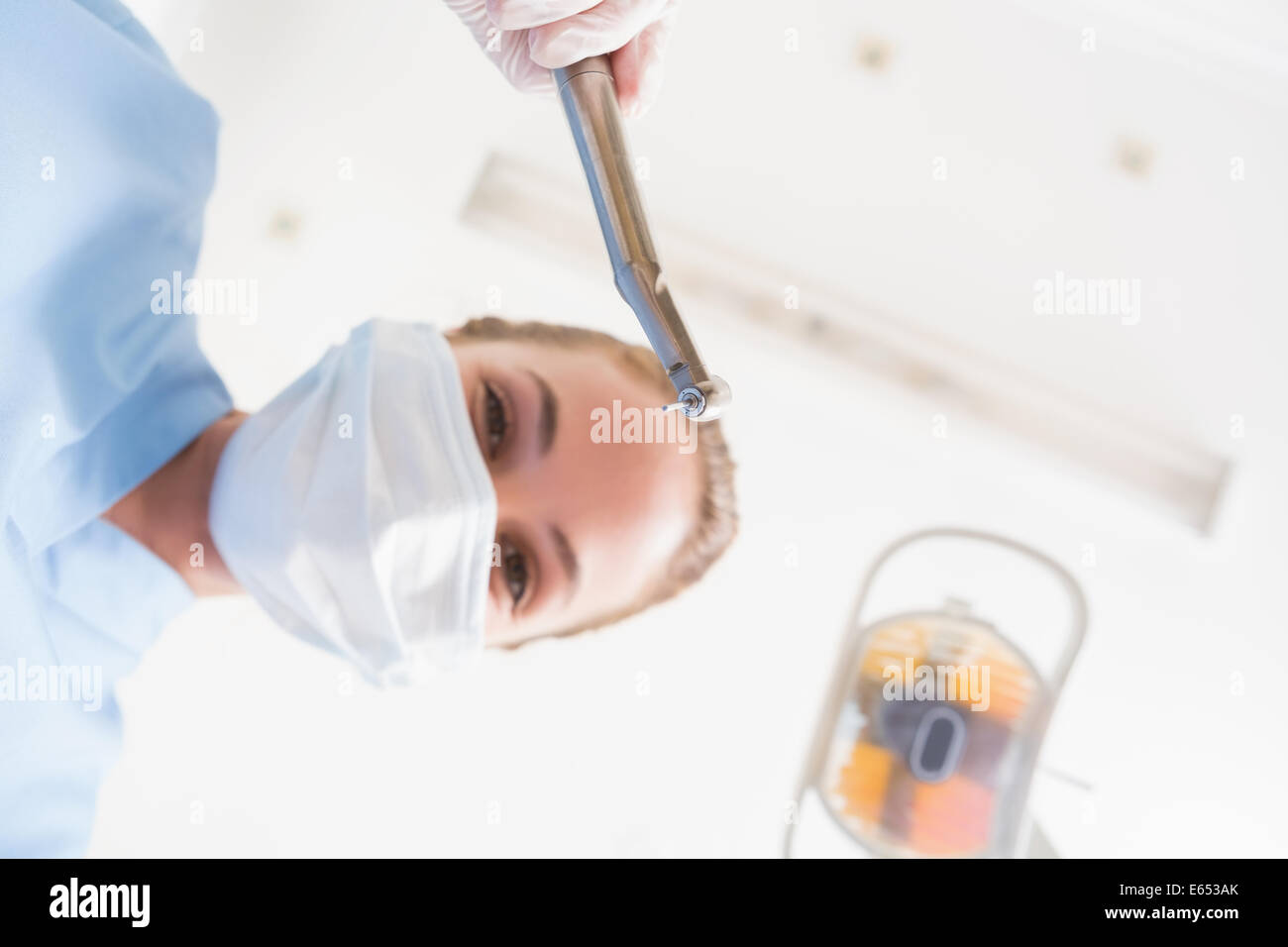 Dentiste en masque chirurgical holding dentaires sur patient Banque D'Images