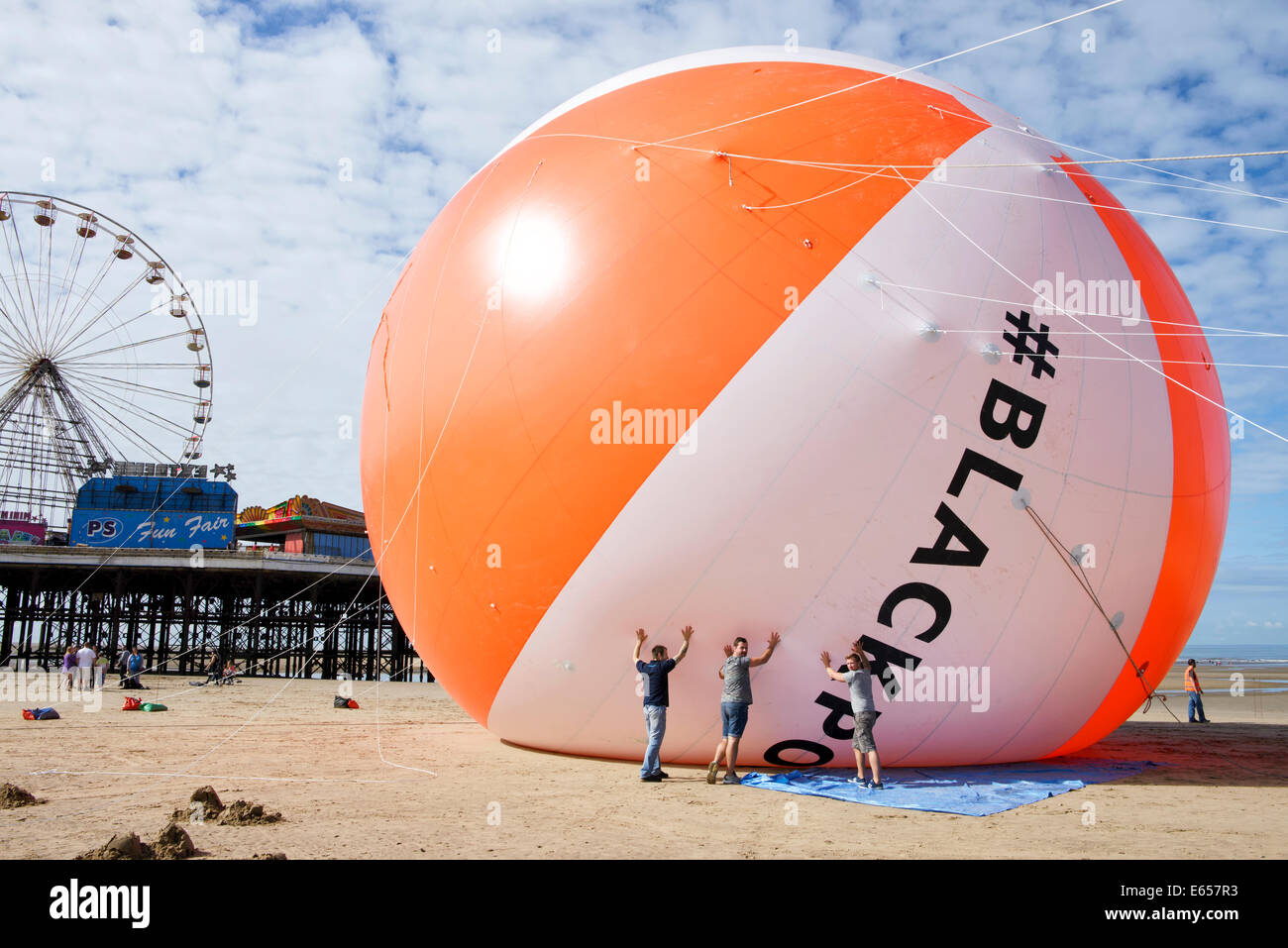 Blackpool détient maintenant le record Guiness pour le plus grand ballon de plage dans l'histoire. La station balnéaire avait sa réalisation validée par Guiness Records comme il a gonflé le ballon d'un diamètre de 18 mètres sur la plage adjacente à Central Pier à Blackpool. Le ballon de plage est de trois fois la taille d'une maison typique et est la même hauteur que la Maison Blanche à Washington DC, USA. Vendredi 15 Août 2014 Banque D'Images