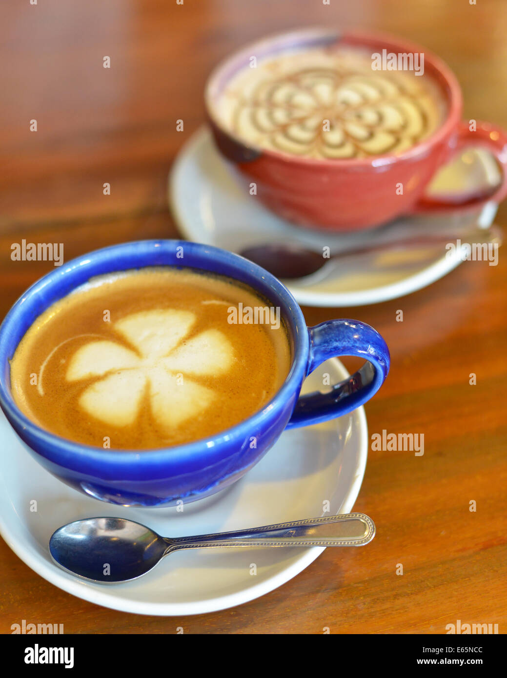 Tasses de café avec du lait sur une table en bois. Banque D'Images