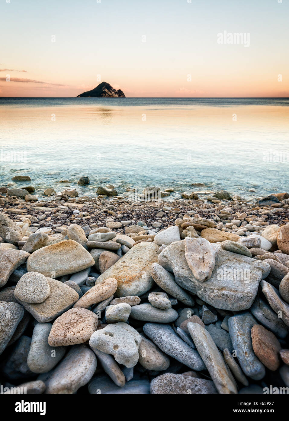 Des pierres lisses sur plage et île lointaine dans horizon Banque D'Images