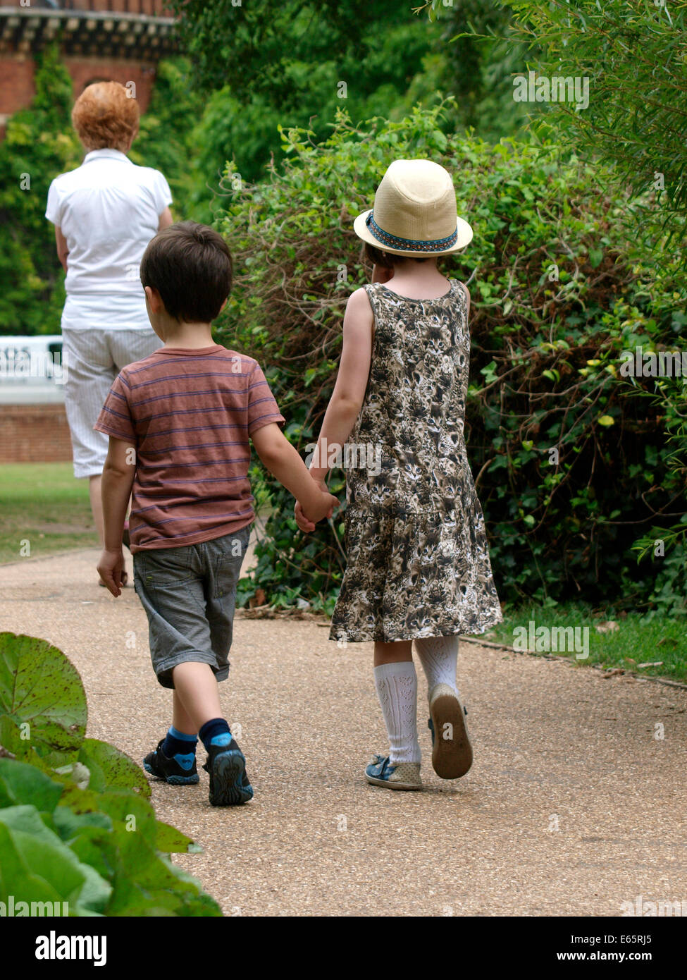Jeune garçon et fille qui marche le long de se tenir la main, UK Banque D'Images