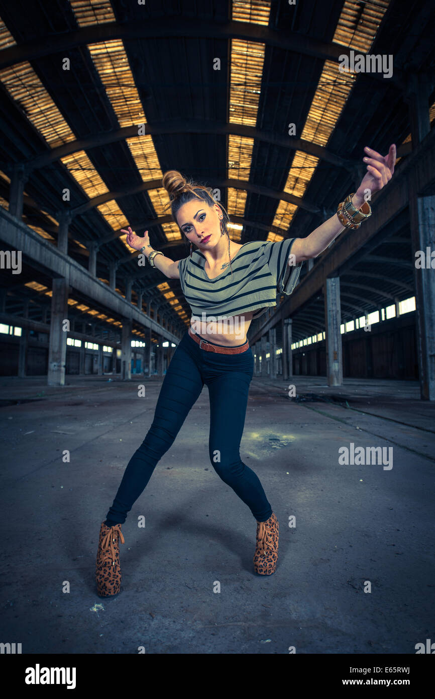 Danseur Hip hop dans un hall industriel abandonné en arrière-plan Banque D'Images