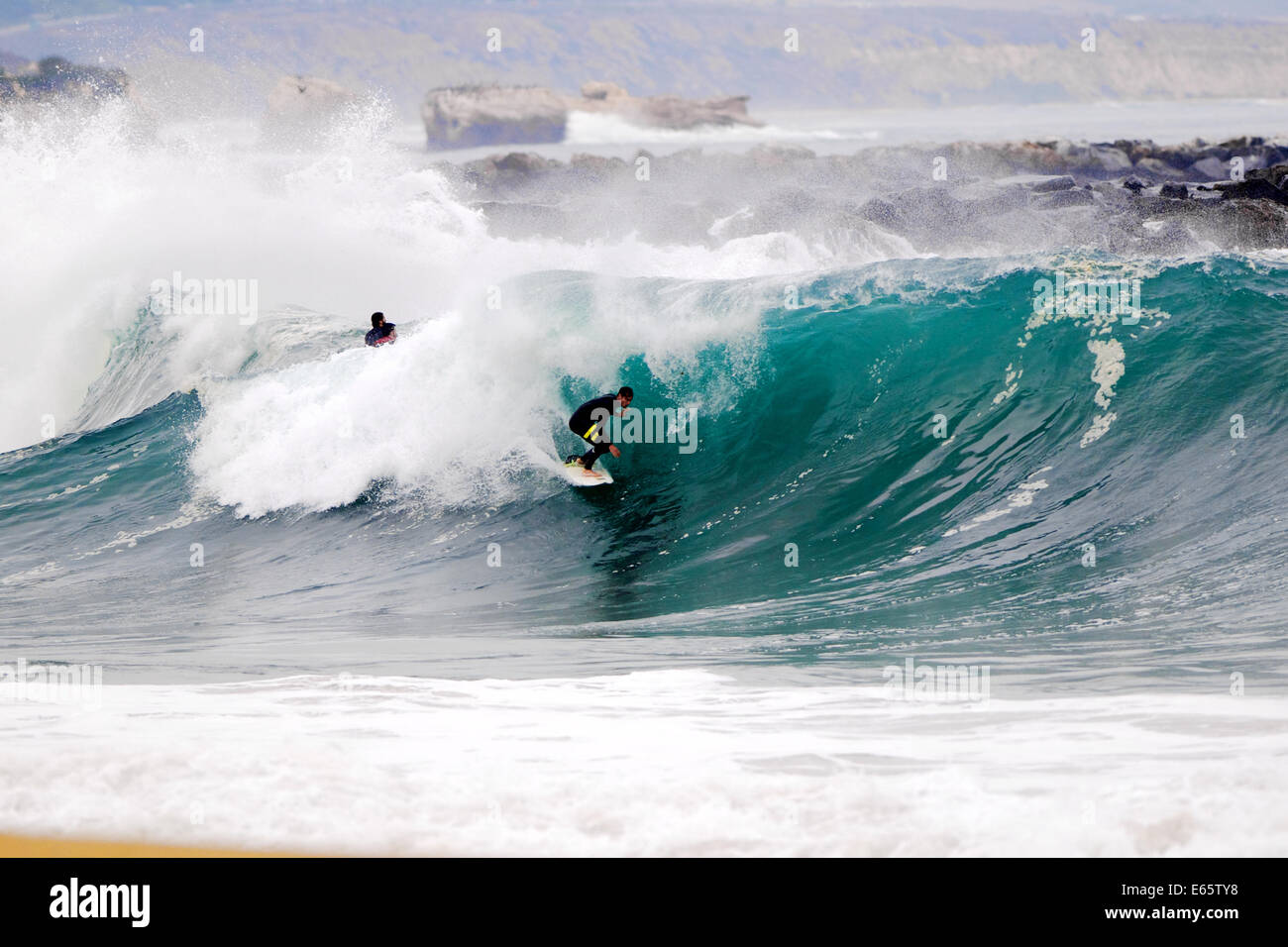 Un surfeur local en tire une lourde, port brisant le baril en eau peu profonde à la surf The Wedge, à Newport Beach, CA Banque D'Images