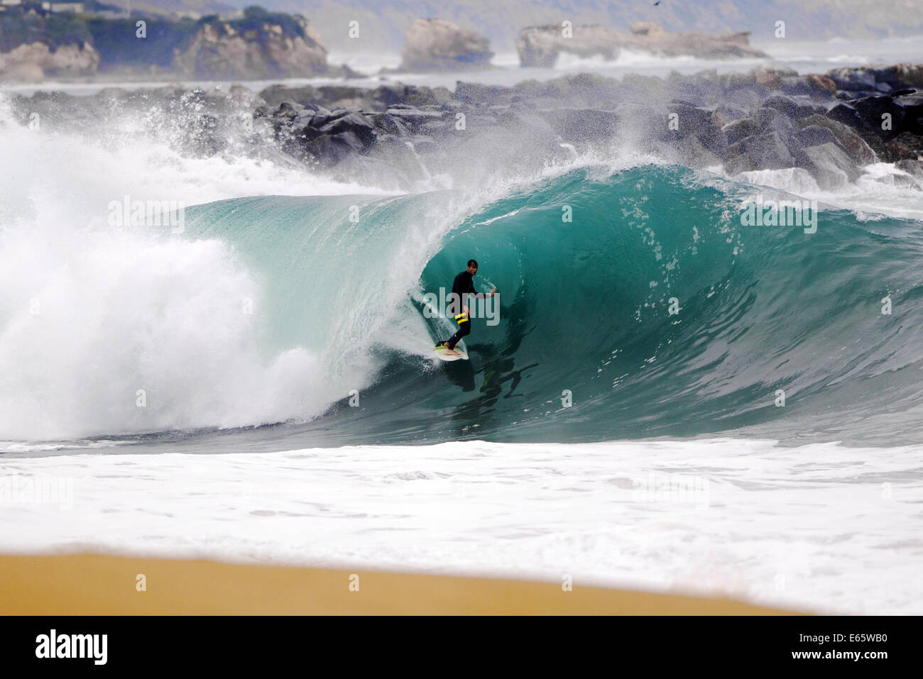Un surfeur local en tire une lourde, port brisant le baril en eau peu profonde à la surf The Wedge, à Newport Beach, CA Banque D'Images