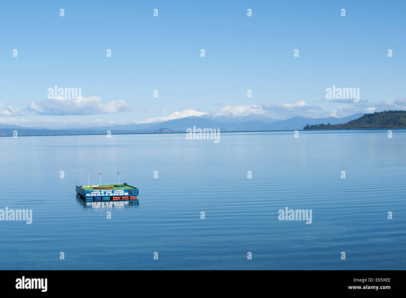 Le lac Taupo, trou dans une plate-forme flottante avec des montagnes enneigées en arrière-plan. Banque D'Images