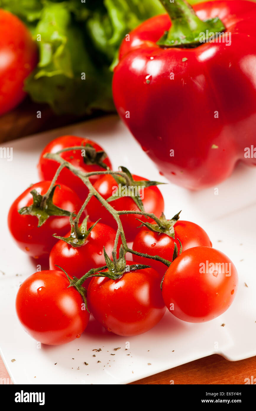 Salade de tomates sur une plaque sur une table en bois Banque D'Images