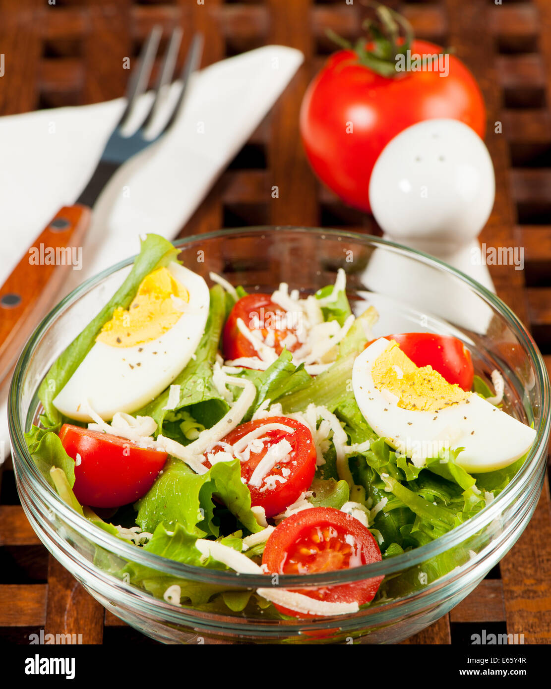 Salade de tomates sur une plaque sur une table en bois Banque D'Images