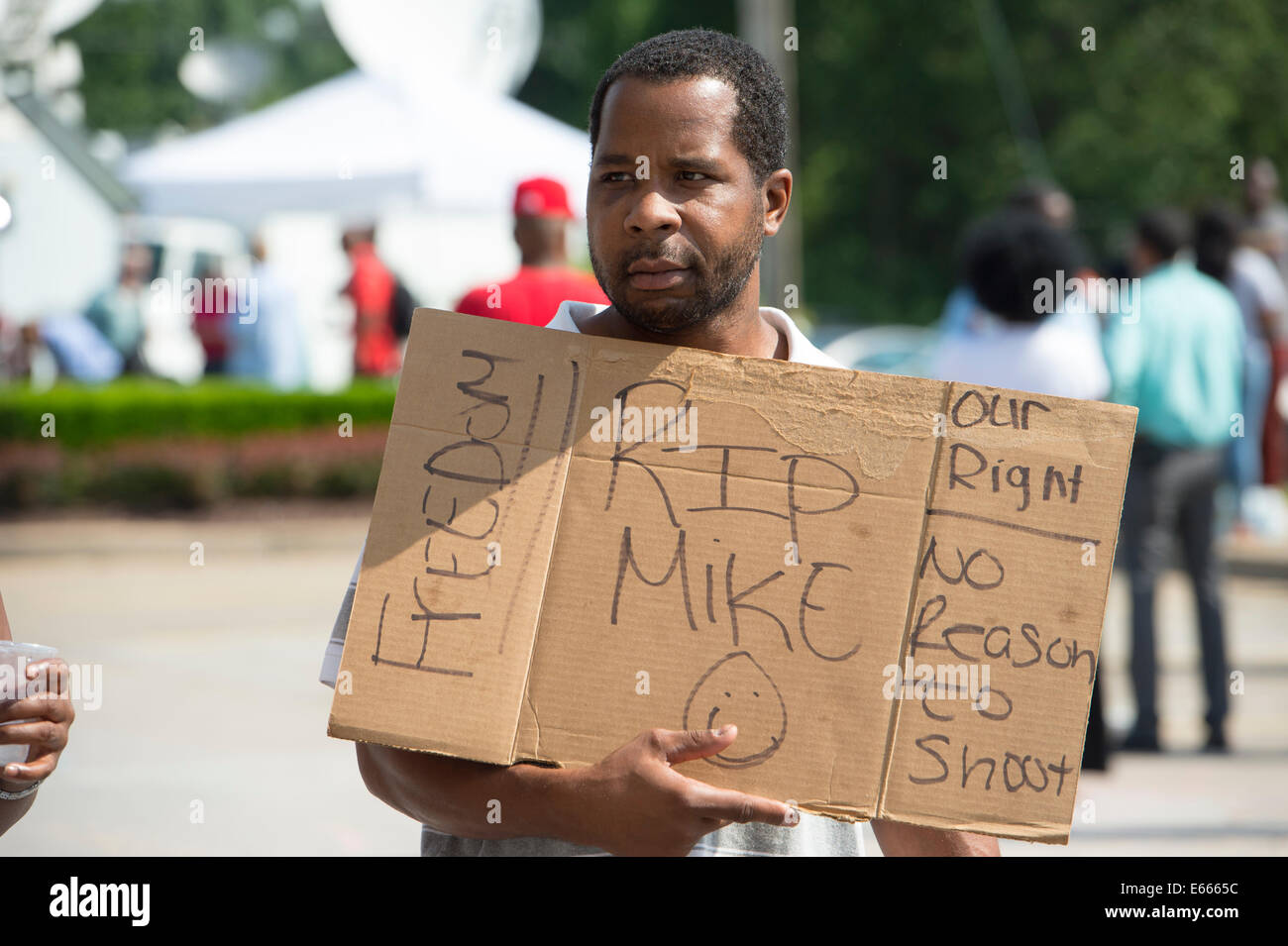 Ferguson, MO, USA. Le 15 août 2014. Manifestant est titulaire signe en le site de voyage rapide détruit après que la police Le chef Thomas Jackson sortie du nom de l'agent que shot Michael Brown. Banque D'Images