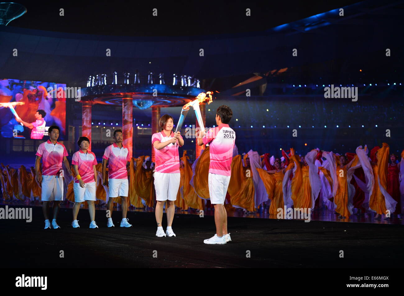 (140816) -- Nanjing, 16 août 2014 (Xinhua) -- course à pied athlète chinois Chen Ding reçoit la flamme de la nageuse chinoise Tang Yi lors de la Nanjing 2014 Cérémonie d'ouverture des Jeux Olympiques de la jeunesse à Nanjing, capitale de la province de Jiangsu, Chine orientale. (Xinhua/Li Xiang)(hhx) Banque D'Images