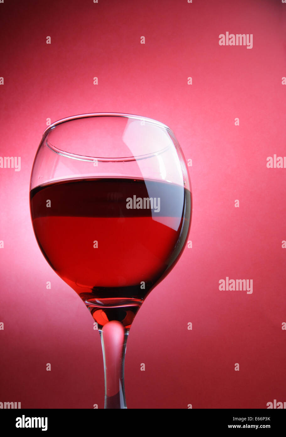 Verre de vin rouge sur fond rouge Banque D'Images