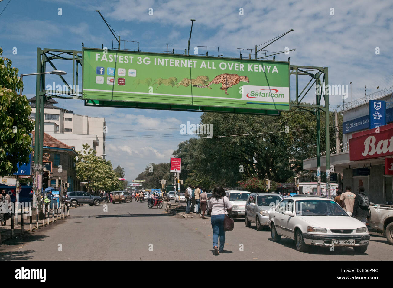 Personnes et de la circulation sur l'avenue Kenyatta Nakuru Kenya Afrique de l'Est avec l'accumulation de la publicité pour le réseau 3G Banque D'Images