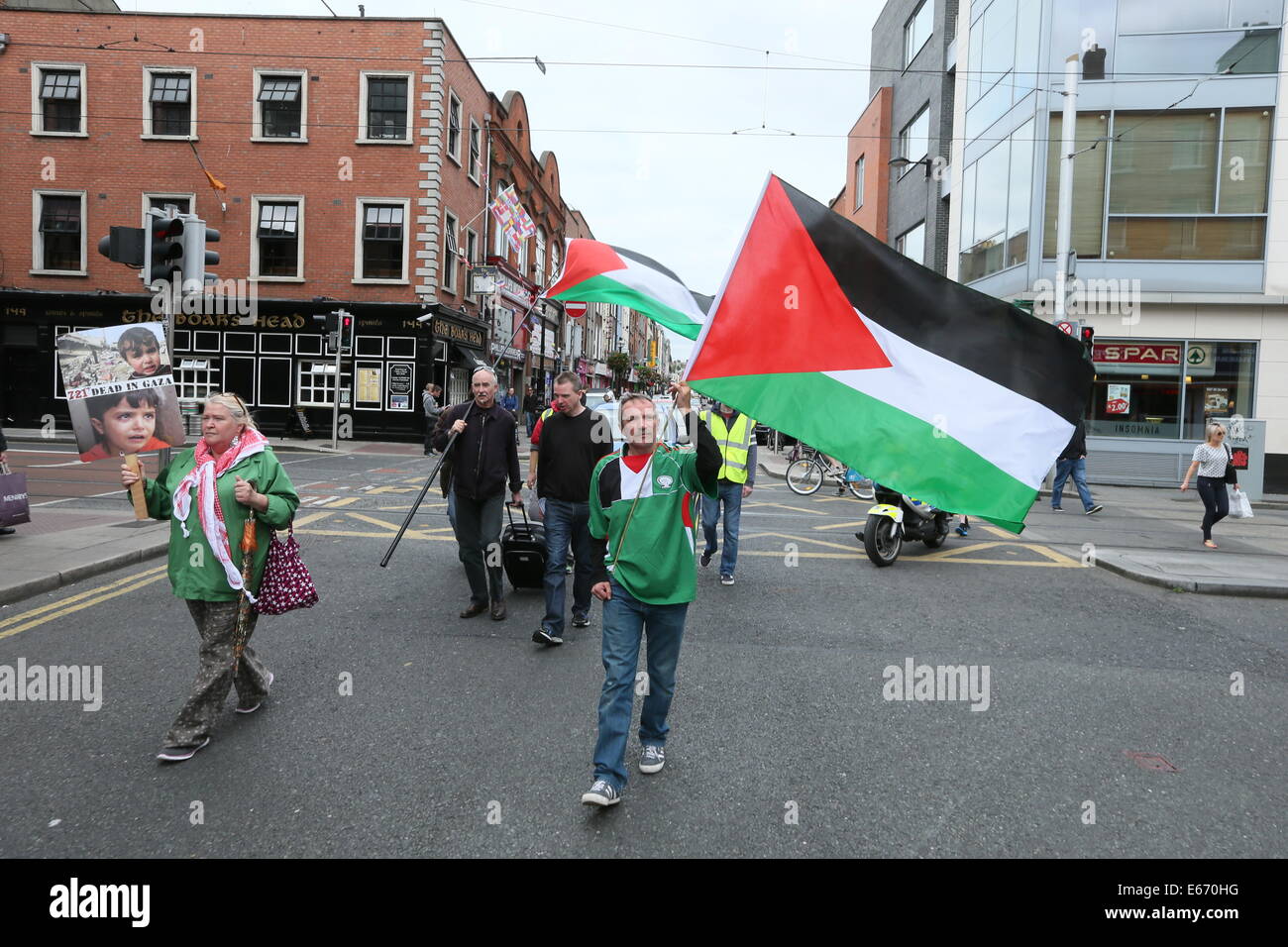 Dublin, Irlande. 16e Août, 2014. Un homme nous tend un drapeau palestinien au cours de la "boycotter les produits israéliens" de protestation dans le centre-ville de Dublin. L'événement. doté d'un mars à Dublin, Henry Street, artère principale de détail est organisée par l'Irlande- Campagne de Solidarité Palestine (IPSC) Credit : Brendan Donnelly/Alamy Live News Banque D'Images