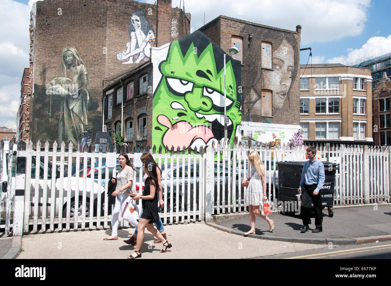 Leonard Street, Londres. L'Art de rue sur les bâtiments avec de jeunes personnes marchant passé au soleil Banque D'Images