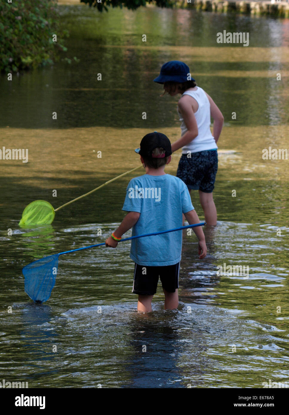 Deux jeunes garçons avec des filets de pêche dans la rivière, Bourton on the water, Gloucestershire, Royaume-Uni Banque D'Images