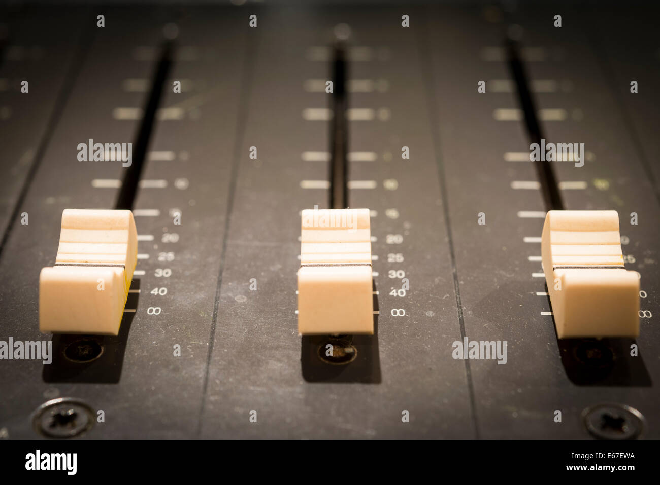 Trois curseurs de volume sur une table de mixage audio close up avec profondeur de champ étroit Banque D'Images