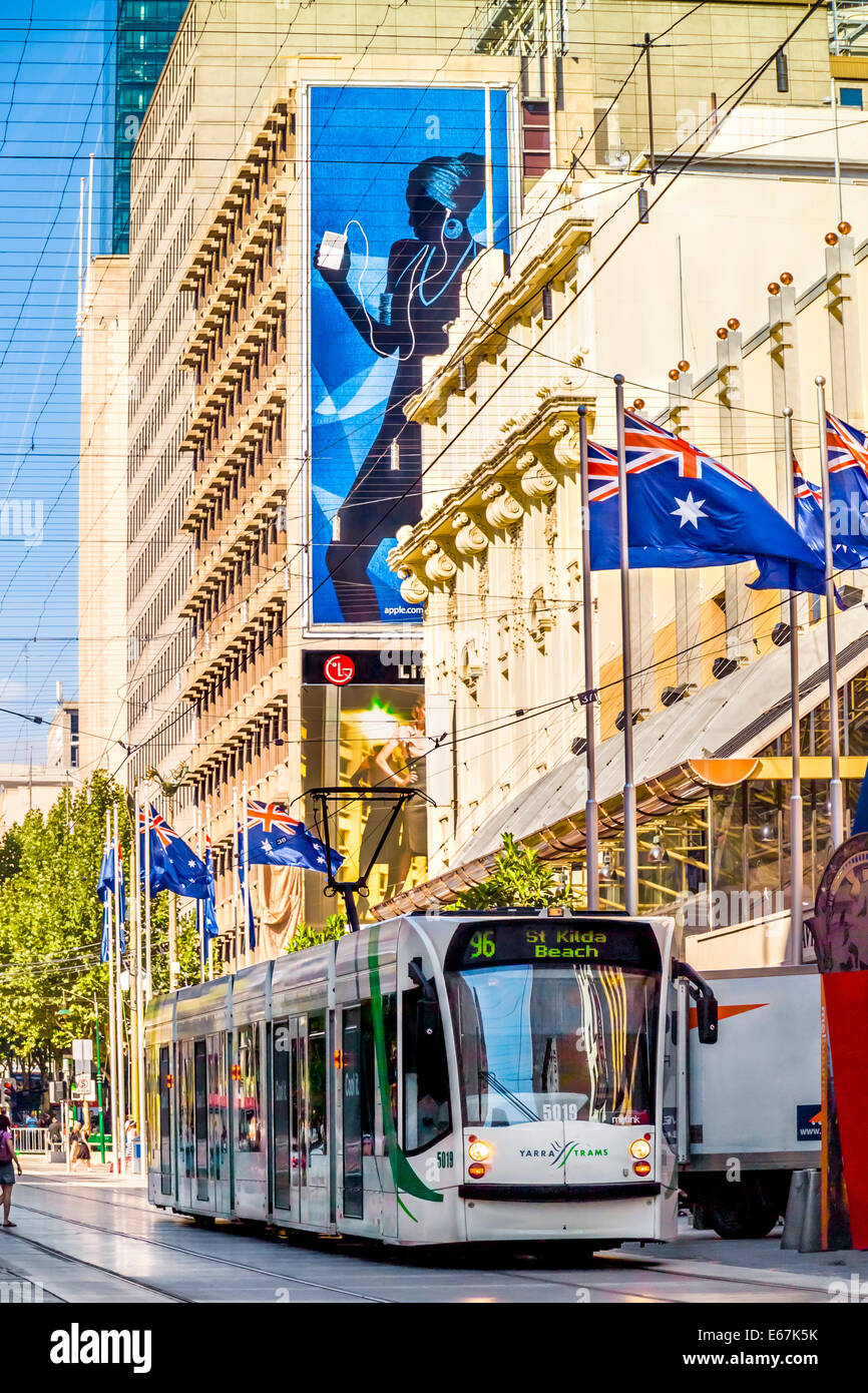 Le tramway moderne dans le quartier commerçant de la ville de Melbourne sur Bourke Street entre les drapeaux de l'Australie. Banque D'Images