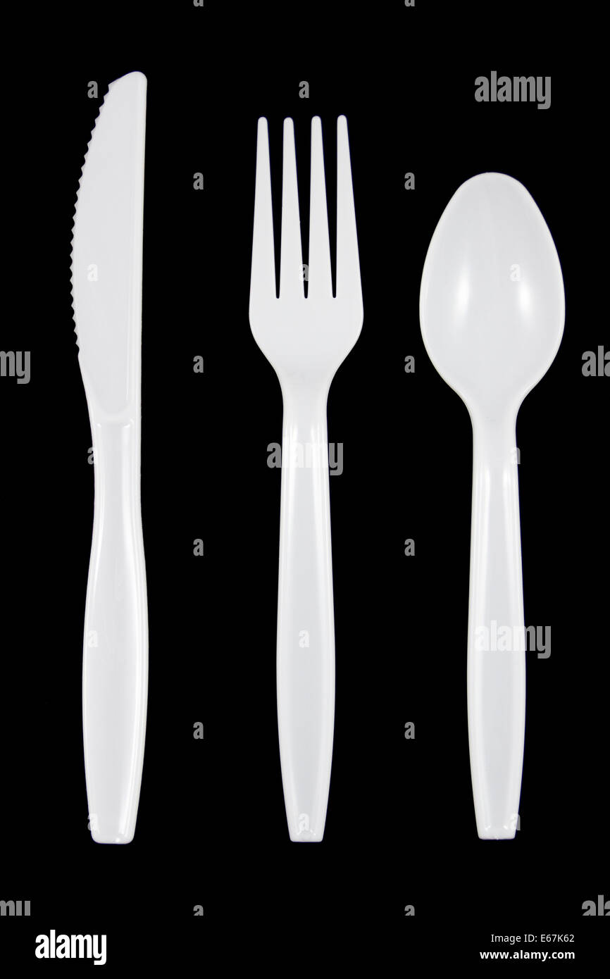 Plastique blanc couteau, fourchette et cuillère sur fond noir. Banque D'Images