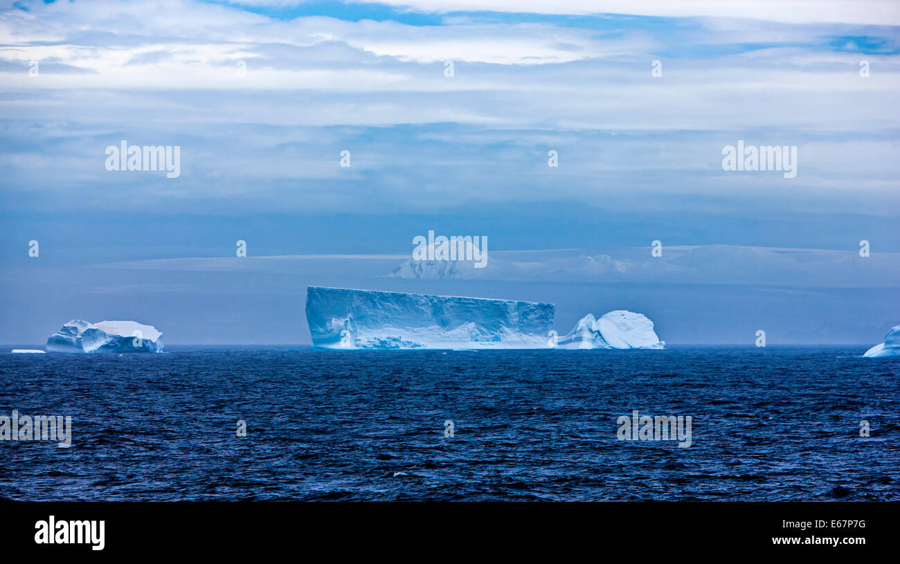 Antarctic iceberg flottant dans l'océan. Dégradé bleu entre l'eau, les nuages, le ciel et la neige. Prise ; le 27 décembre 2011. Banque D'Images
