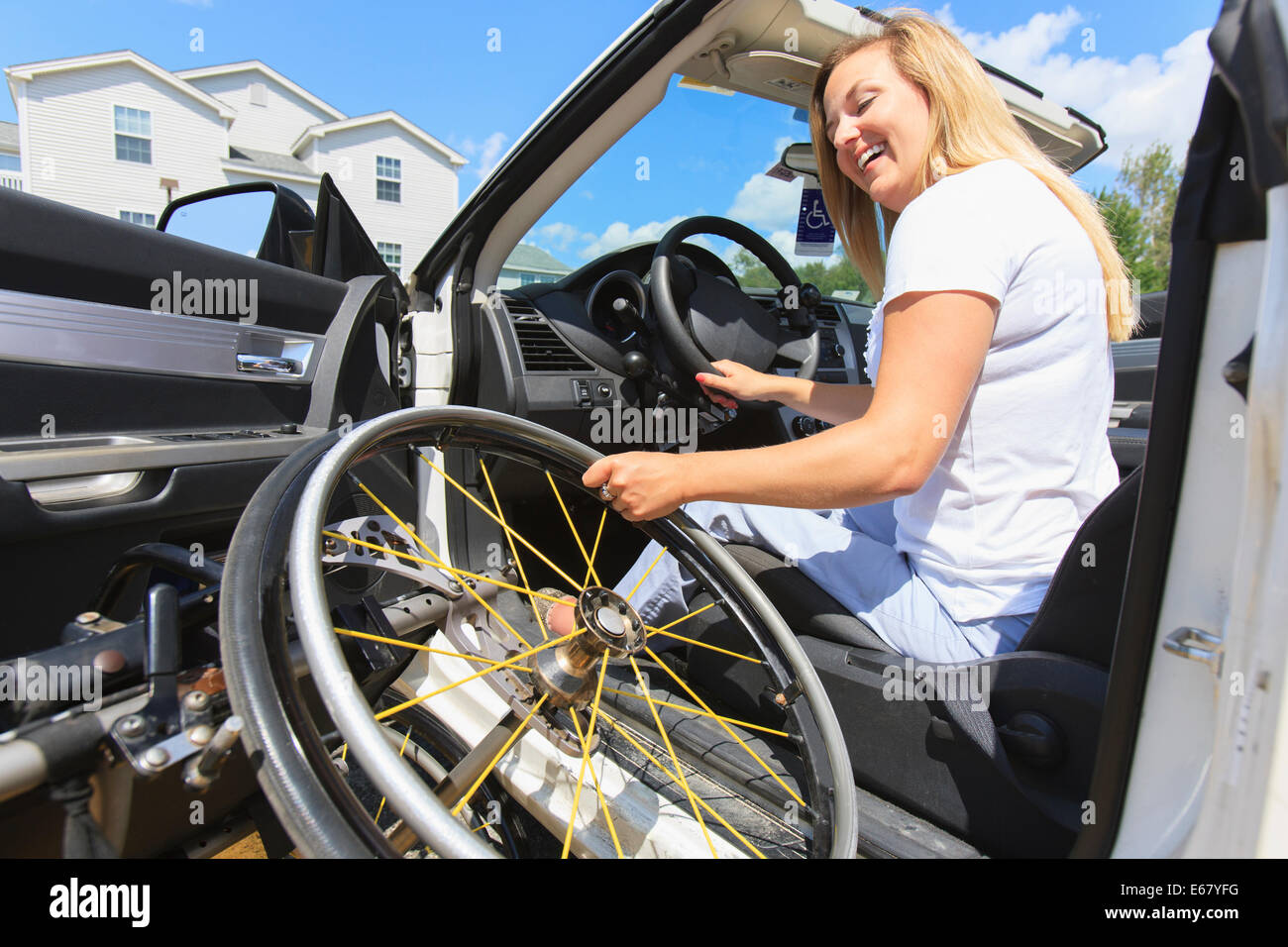 Femme avec la moelle épinière tirant son fauteuil roulant à véhicule adaptative Banque D'Images