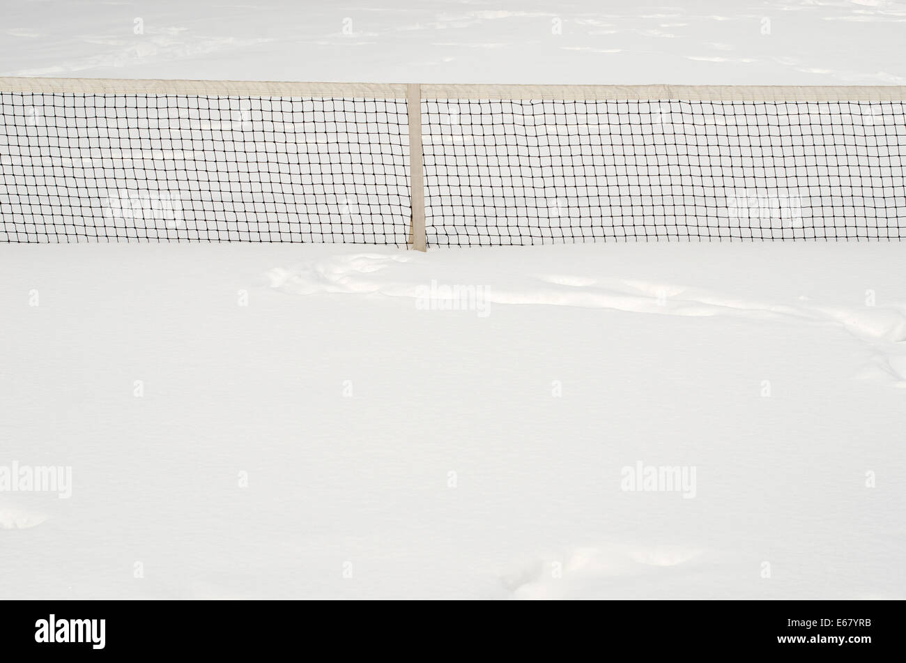 Filet de tennis, à moitié enfoui dans la neige profonde, blanc. Banque D'Images
