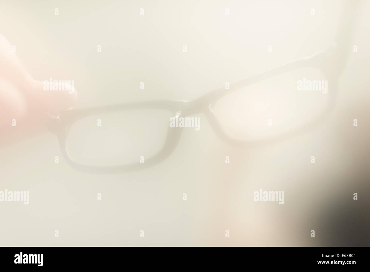 Hand of man holding eyeglasses dans la salle de bain remplie de vapeur. Image conceptuelle de visibilité, de voir et de problèmes. Banque D'Images