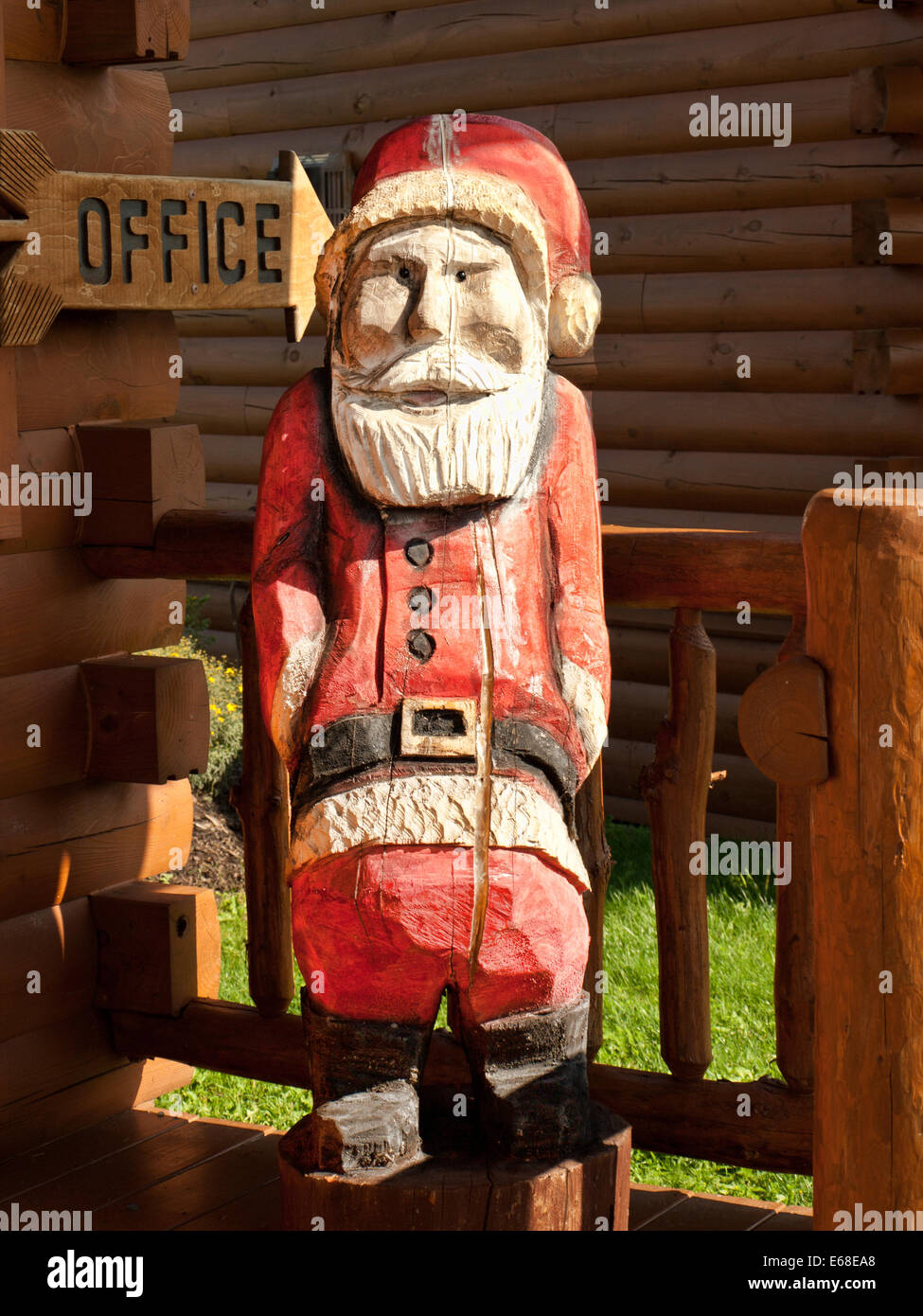 Père Noël en bois figure sur le porche d'une cabane de fabrication Banque D'Images