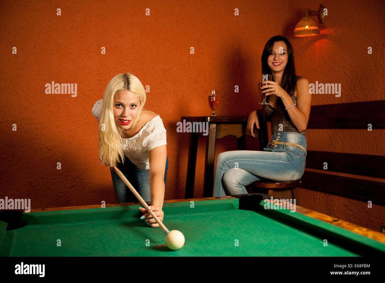 Belle jeune blonde jouant au billard dans un bar Banque D'Images