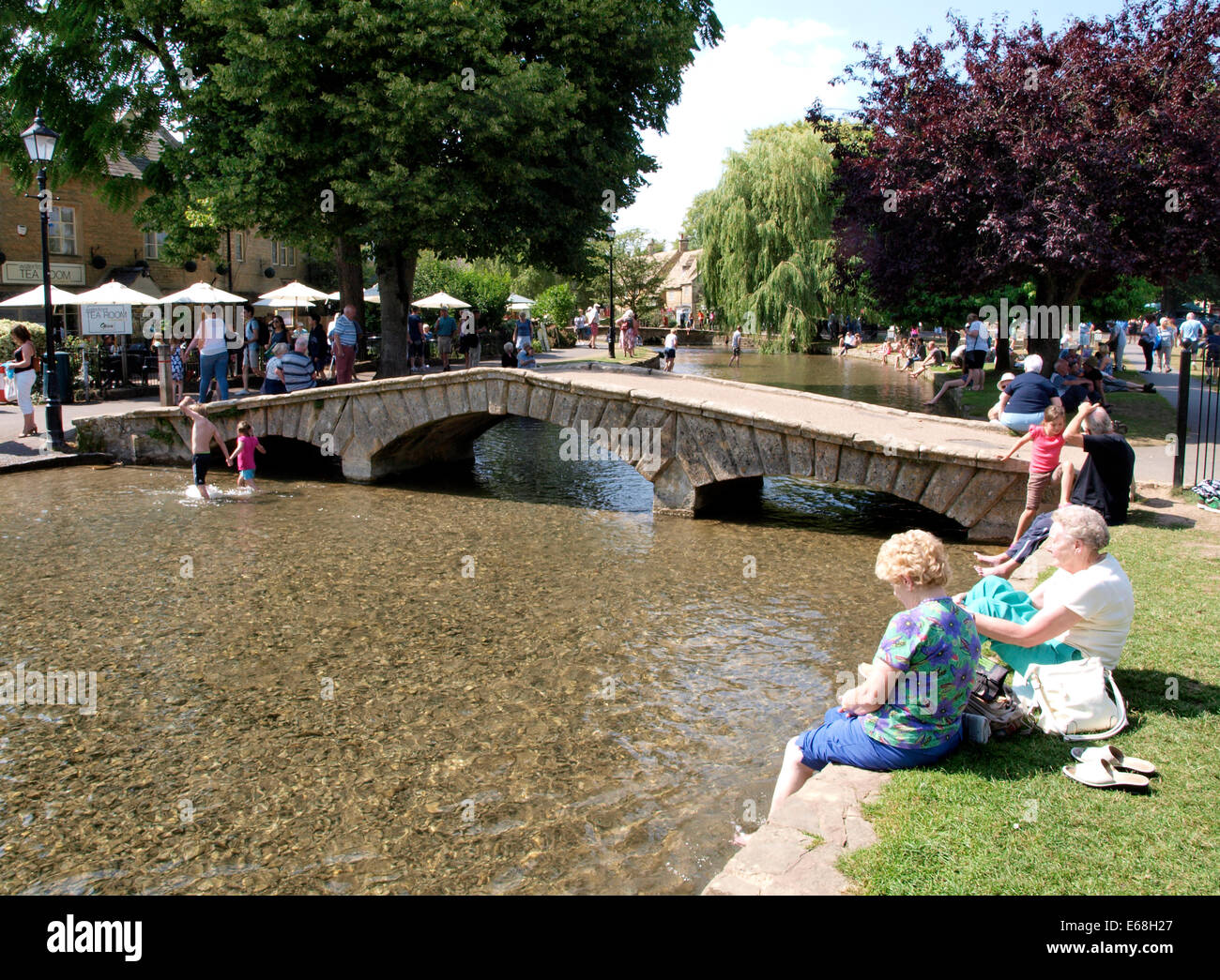 Les personnes bénéficiant de la canicule de l'été par la rivière Windrush, Bourton-on-the-water, Gloucestershire, Royaume-Uni 30/07/2014 Banque D'Images