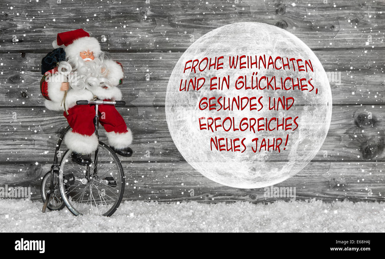 Carte de joyeux Noël en rouge et blanc avec texte allemand et un père noël. Banque D'Images