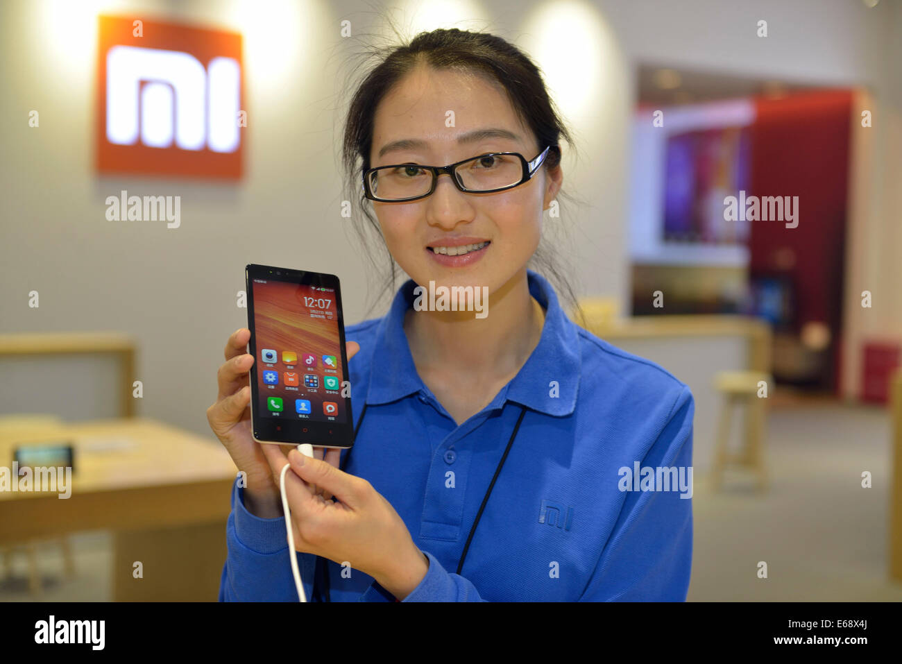 Le personnel d'une fille montre une Redmi Xiaomi Remarque à Xiaomi Experience Center à Beijing, Chine. 27-Mar-2014 Banque D'Images