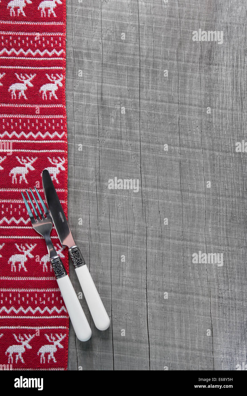 Couteaux et fourchettes en bois sur fond de Noël en rouge pour une carte des menus. Banque D'Images