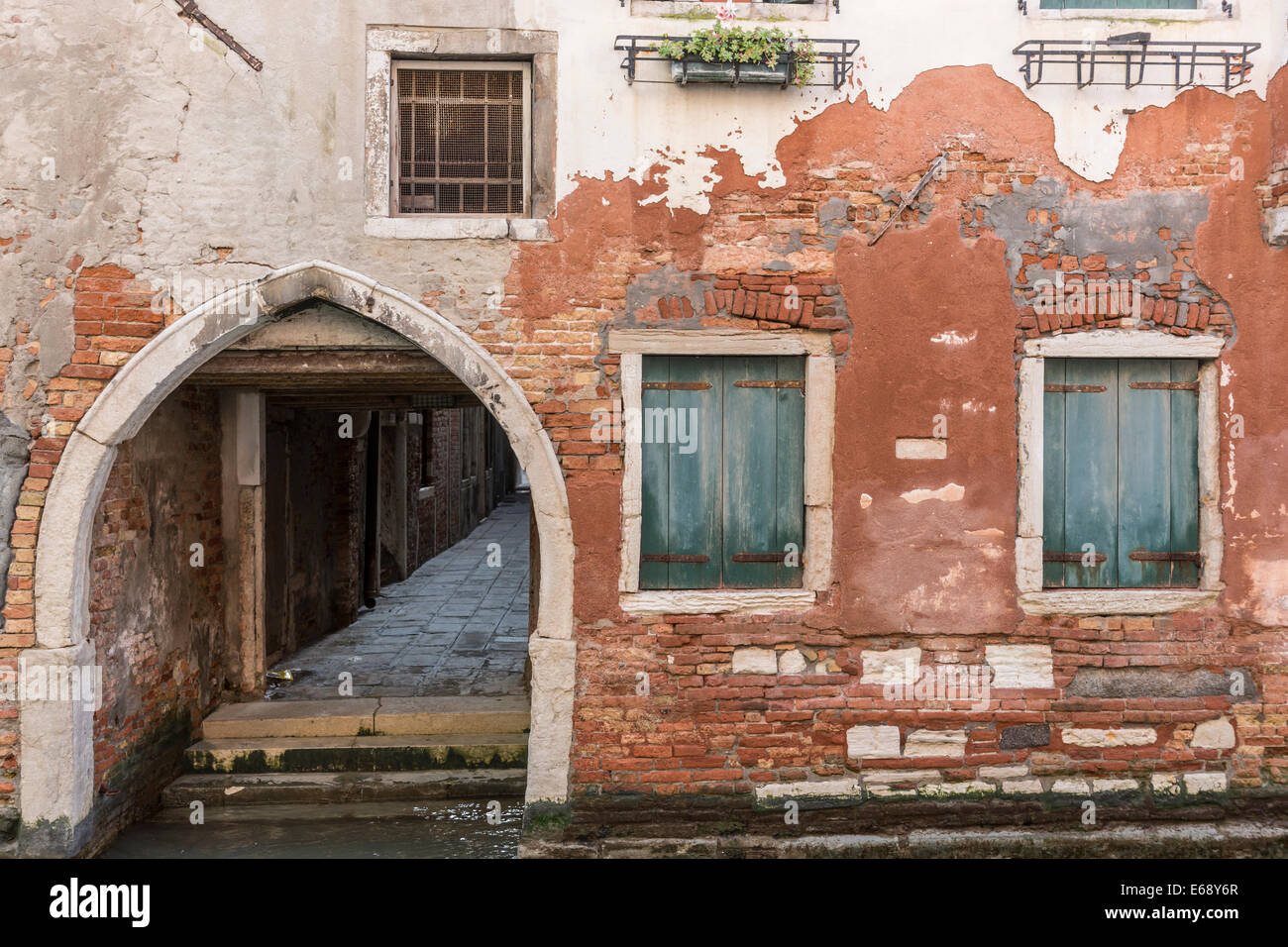 L'édicule voûté terrain adjacent, fenêtres donnant sur un canal latéral à Venise. Banque D'Images