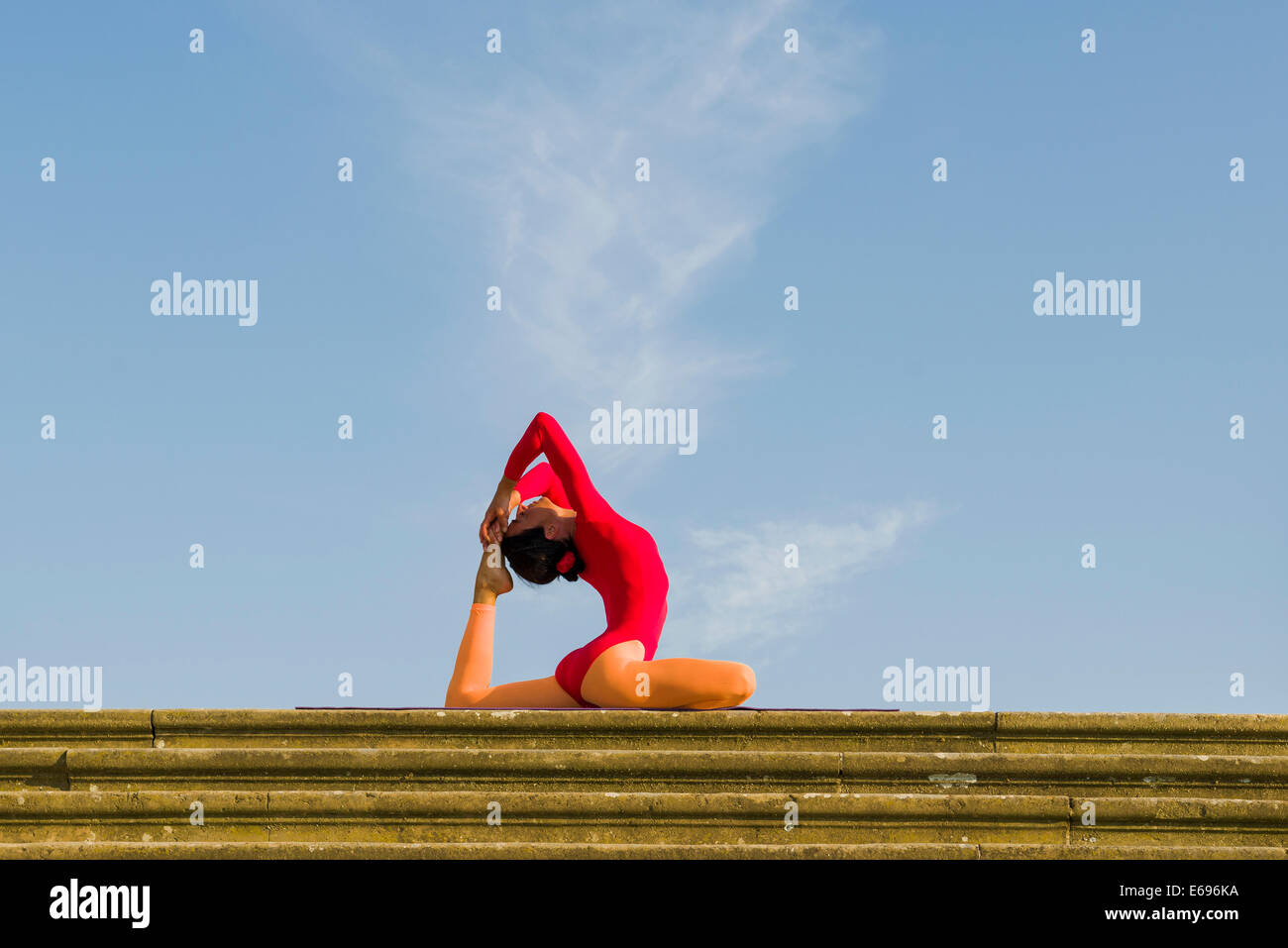 Jeune femme la pratique de l'Hatha Yoga, à l'extérieur, montrant la posture, Kapotasana posent Pigeon Banque D'Images