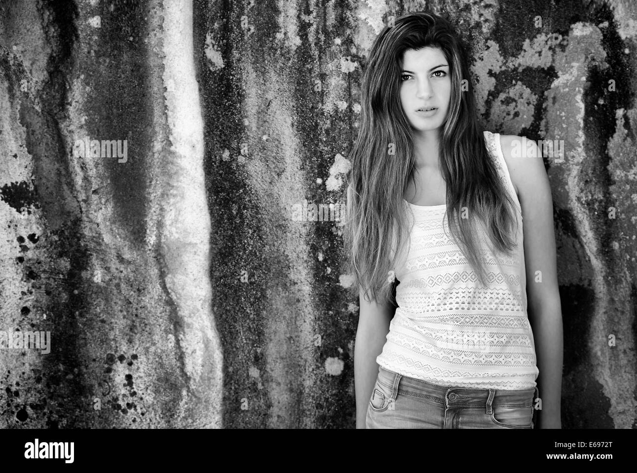 Girl with long hair, 15 ans, debout devant un vieux mur vieilli Banque D'Images