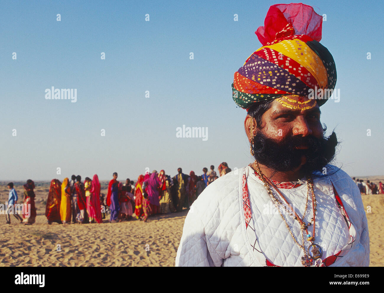 L'homme hindou habillé de façon traditionnelle. Il appartient à la classe de Rajput. Dans l'arrière-plan, les femmes sont visibles (Inde) Banque D'Images