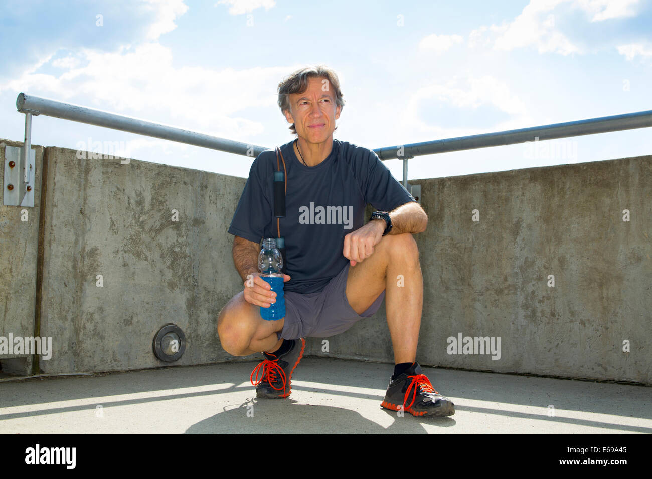 Caucasian runner reposant on urban rooftop Banque D'Images