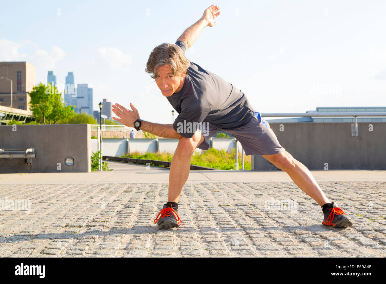 Caucasian man stretching en parc urbain Banque D'Images