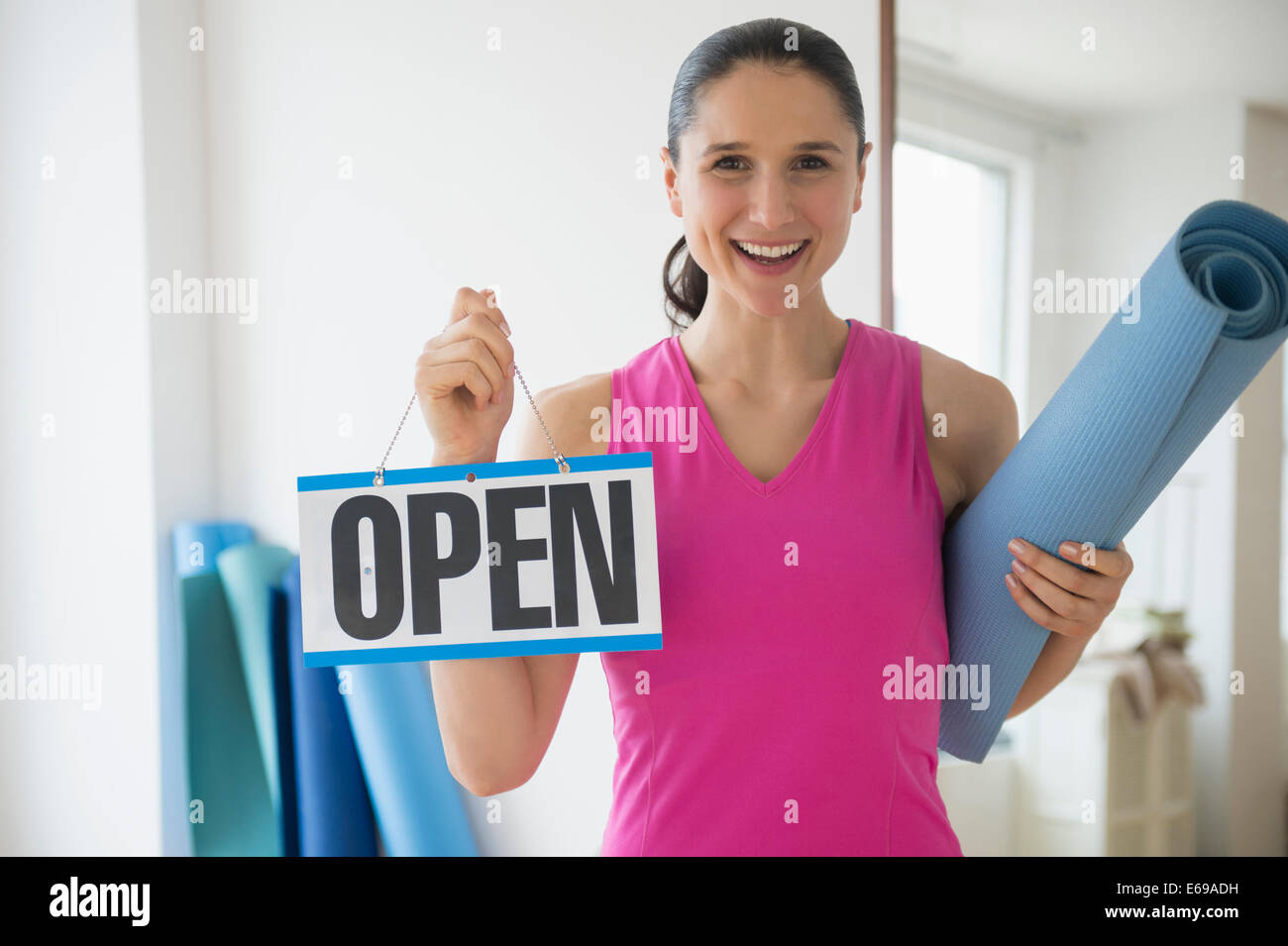 Caucasian woman holding open sign in yoga studio Banque D'Images