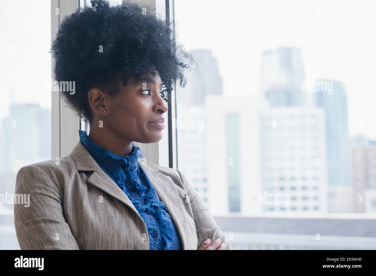 Black businesswoman looking out office window Banque D'Images