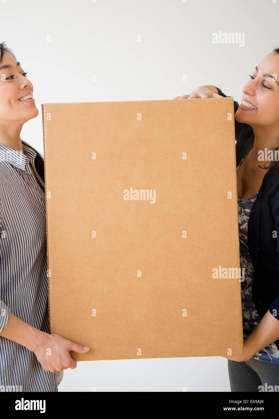 Des femmes portant des boîte en carton ensemble Banque D'Images